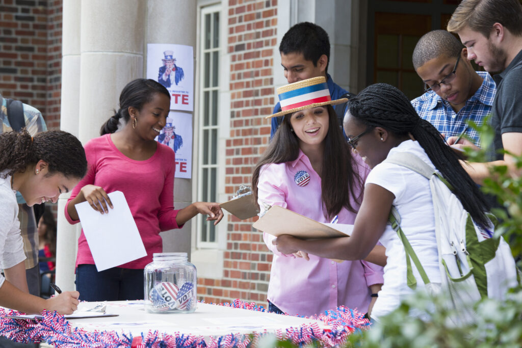 Stock image of students encouraging others to register to vote.