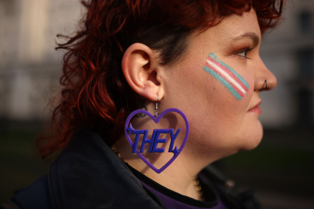 LONDON, ENGLAND - JANUARY 17: Trans rights activist Lilly wears an earring featuring a 'they' pronoun symbol, during a protest outside the Ministry of Defence Main Building in Whitehall on January 17, 2023 in London, England.