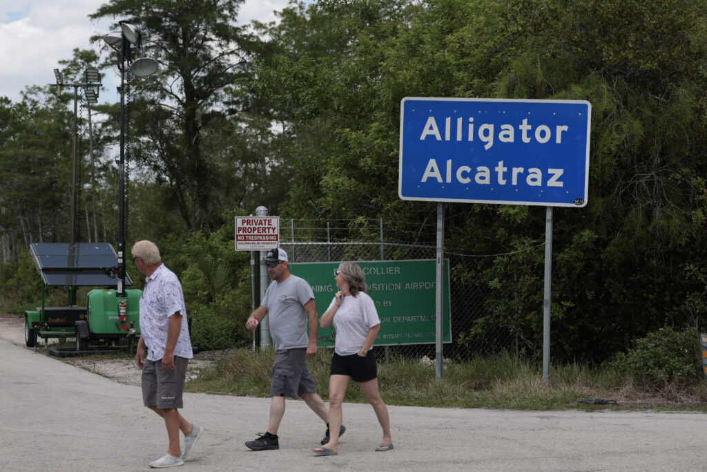 People walk near the front entrance to the immigration detention center in the Florida Everglades known as “Alligator Alcatraz" on April 22, 2026, in Ochopee, Florida.